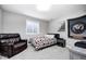 A cozy bedroom with carpet, a bed, a chair, and a window at 18820 Wychwood Pl, Noblesville, IN 46062