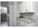 A hallway features white cabinets with granite countertop adjacent to a staircase at 18820 Wychwood Pl, Noblesville, IN 46062