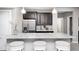Elegant kitchen bar with granite countertops, dark wood cabinets, and stainless steel refrigerator at 18820 Wychwood Pl, Noblesville, IN 46062