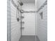 Modern shower featuring white subway tile, a rainfall showerhead, and built-in shelving at 18820 Wychwood Pl, Noblesville, IN 46062