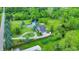 Aerial view of a property with a scenic pond, verdant landscaping, and a circular driveway at 1933 S 825 E, Zionsville, IN 46077
