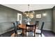 Formal dining room features dark walls, a wood table, and modern lighting fixtures at 1933 S 825 E, Zionsville, IN 46077
