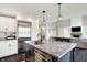 Open kitchen with a large island, stainless steel refrigerator, and access to the living room at 1933 S 825 E, Zionsville, IN 46077