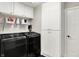 Efficient laundry room equipped with sleek, front load washer and dryer, and ample storage cabinets at 1933 S 825 E, Zionsville, IN 46077