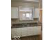 Kitchen view with white cabinets, a dual stainless sink, and a view into the living room at 2202 E Brookside Ave, Indianapolis, IN 46218