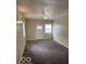 View of the living room with neutral walls and carpet, plus a white front door and window at 2202 E Brookside Ave, Indianapolis, IN 46218