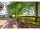 Stained backyard deck features wrought-iron table and bench with a view of a lush lawn and mature trees at 2221 W County Road 500 N, Danville, IN 46122