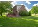 Image shows a cozy backyard featuring a stained deck, brick home and well manicured green lawn at 2221 W County Road 500 N, Danville, IN 46122