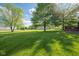Backyard is adorned with green grass and mature trees, creating a beautiful outdoor space at 2221 W County Road 500 N, Danville, IN 46122