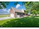 Image shows a charming brick home with an attached garage and stained wooden deck at 2221 W County Road 500 N, Danville, IN 46122