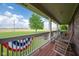 Charming front porch with rocking chairs, decorative bunting, and a serene view of the expansive front yard at 2221 W County Road 500 N, Danville, IN 46122