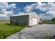 Large tan garage/outbuilding with two windows, white garage door, and gravel parking at 2221 W County Road 500 N, Danville, IN 46122