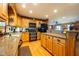 Well-equipped kitchen with custom wood cabinets, modern appliances, and a breakfast bar that opens to the dining space at 2221 W County Road 500 N, Danville, IN 46122
