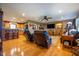 Spacious living room with hardwood floors, leather furniture, a ceiling fan, and an open view into the kitchen at 2221 W County Road 500 N, Danville, IN 46122