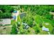 Extensive property with multiple outbuildings, pond, pool, and homes surrounded by trees from an aerial view at 2240 Bill Smith Rd, Martinsville, IN 46151