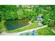 Stunning aerial view showcases a pond, pool, green lawn, and charming red-roofed home at 2240 Bill Smith Rd, Martinsville, IN 46151