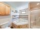 Bright bathroom featuring a corner bathtub with tile surround and a separate shower with sliding glass doors at 2240 Bill Smith Rd, Martinsville, IN 46151