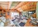Open living room features exposed wood beams, wood paneling, stone fireplace, and hardwood floors at 2240 Bill Smith Rd, Martinsville, IN 46151