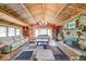Open living room features exposed wood beams, wood paneling, stone fireplace, and hardwood floors at 2240 Bill Smith Rd, Martinsville, IN 46151