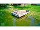 Enjoy relaxing on your dock at the pond with a bench and storage bin overlooking the water surrounded by greenery at 2240 Bill Smith Rd, Martinsville, IN 46151