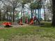 Vibrant community playground with colorful equipment and a backdrop of mature trees at 2710 Fairview St, Anderson, IN 46011