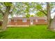 Spacious backyard features a brick house, wooden deck, and lush green lawn with mature trees at 331 W 5Th St, Lapel, IN 46051
