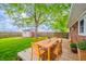 The backyard has a wooden deck with an outdoor dining set and a shed surrounded by a green lawn and trees at 331 W 5Th St, Lapel, IN 46051