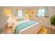 Bright bedroom featuring a white bed, two windows with light blue curtains, and cheerful wall art at 331 W 5Th St, Lapel, IN 46051