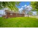 Exterior view of a brick home with a lush green lawn and mature trees in a residential neighborhood at 331 W 5Th St, Lapel, IN 46051