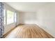 Bright and airy living room featuring gleaming hardwood floors and a large window with decorative curtains at 331 W 5Th St, Lapel, IN 46051
