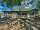 Ranch style home with stone and siding, neutral colors, mature trees, and a covered front porch at 3401 W Kessler Blvd N Dr, Indianapolis, IN 46222