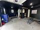 Finished garage includes blue couch, dart board, painted walls and ceiling, and overhead lighting at 3401 W Kessler Blvd N Dr, Indianapolis, IN 46222