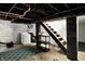 Unfinished basement with exposed ceiling, concrete walls, and access to a wooden staircase at 3609 N Keystone Ave, Indianapolis, IN 46218