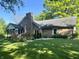 Beautiful backyard with brick house, wooden deck, mature trees, and lush green lawn at 378 Turnberry Ct, Avon, IN 46123