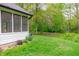 Lush backyard with green grass, mature trees, and a view of the screened-in porch, perfect for outdoor enjoyment at 378 Turnberry Ct, Avon, IN 46123