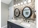 Bathroom featuring double sinks, granite countertops, stylish mirrors, and decorative tile work for an elegant design at 378 Turnberry Ct, Avon, IN 46123