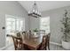 Light and airy dining room with a dark wood table and modern chandelier; view to sunroom at 378 Turnberry Ct, Avon, IN 46123