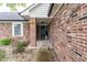 Inviting front entrance featuring a traditional black door, brick siding, and manicured landscaping at 378 Turnberry Ct, Avon, IN 46123