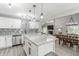 Open concept kitchen with island leading to dining area and living room with stone fireplace feature at 378 Turnberry Ct, Avon, IN 46123