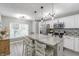 Open kitchen featuring white cabinets, stainless steel appliances and island with seating overlooking the backyard at 378 Turnberry Ct, Avon, IN 46123