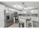 Well-lit modern kitchen with white cabinets, stainless steel appliances, large island, and stylish backsplash at 378 Turnberry Ct, Avon, IN 46123
