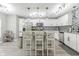 Bright, spacious kitchen with white cabinetry, stainless steel appliances, island with marble counters and seating at 378 Turnberry Ct, Avon, IN 46123