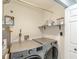 Bright laundry room with modern washer and dryer, shelving, and ample space for efficient chores at 378 Turnberry Ct, Avon, IN 46123