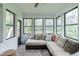 Bright sunroom with large windows, cozy couch, and serene view of the backyard at 378 Turnberry Ct, Avon, IN 46123