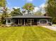 Charming single-story home with well-manicured lawn, mature trees, and a welcoming front porch at 406 Frst Pk N Dr, Greenwood, IN 46142