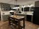 Cozy kitchen showcasing sage green cabinets, quartz countertops, and a central kitchen island at 406 Frst Pk N Dr, Greenwood, IN 46142