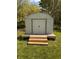 White storage shed on a wooden platform, complete with stairs, set against a green yard and trees at 406 Frst Pk N Dr, Greenwood, IN 46142