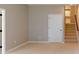 Finished basement area with carpet, a door, and stairs leading up to a kitchen at 4075 Persian St, Greenwood, IN 46143