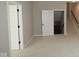 Neutral room with two open doorways showing stairs and another room with a closed white door at 4075 Persian St, Greenwood, IN 46143