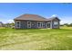 The backyard features a well-maintained lawn and a home exterior with a series of windows and a sliding glass door at 4076 Berry Chase Blvd, Greenwood, IN 46143